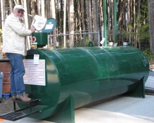 Photo of Graham MacDonald pouring used oil in GIRO's new doudle walled tank.